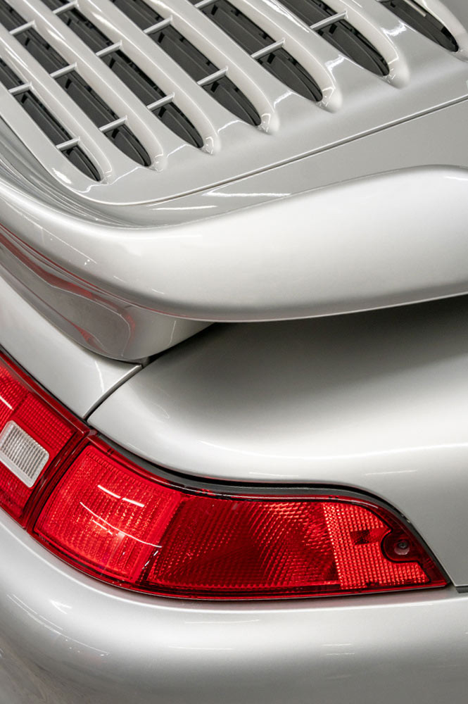 Heck eines silbernen Porsches seitlich fotografiert