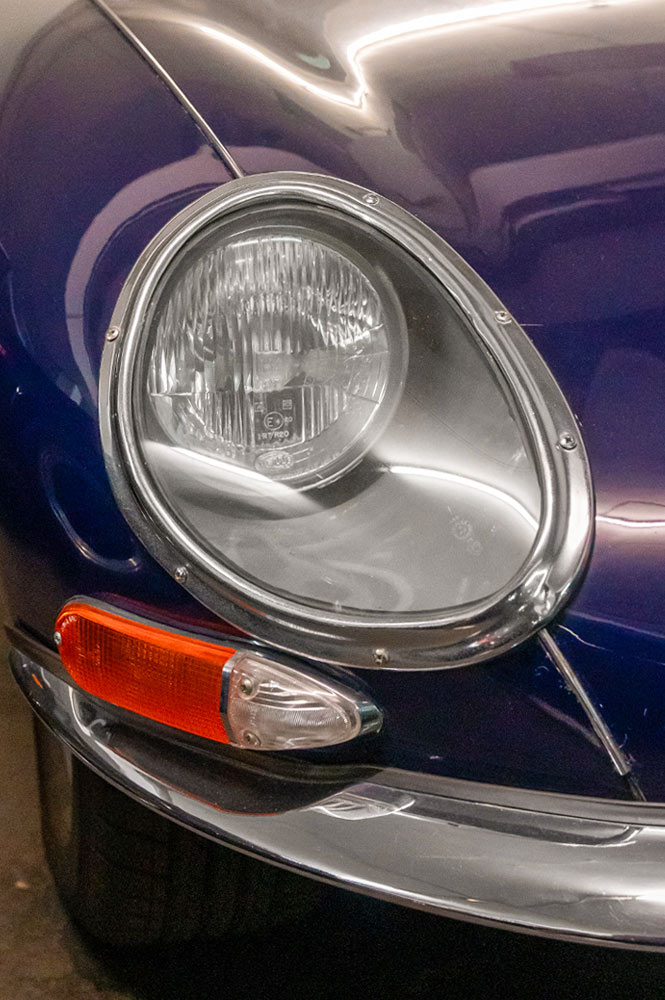 Linker Frontscheinwerfer eines dunkellila farbenden Jaguar e-Type