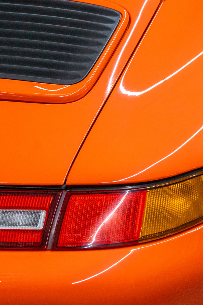 Ausschnitt einer Heckansicht eines orangen Porsches